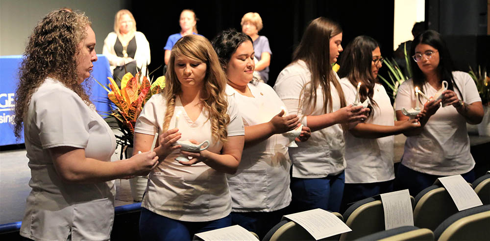 Vocational Nursing Program graduates light symbolic candles before reciting the Vocational Nurses’ Pledge.